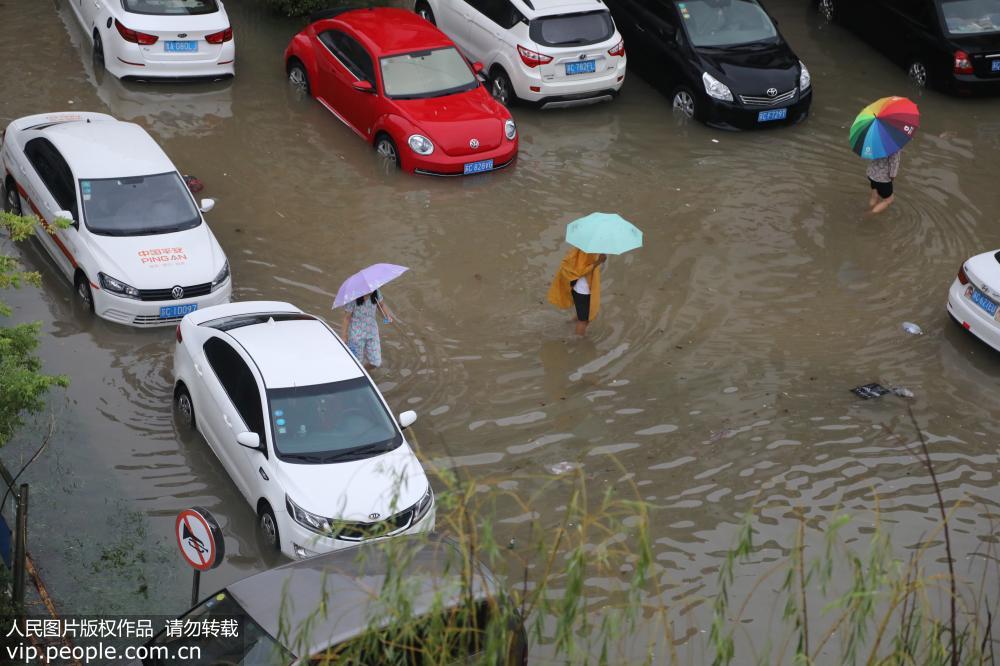 2018年8月19日，江蘇豐縣城區一片汪洋，行人車輛涉水而行。