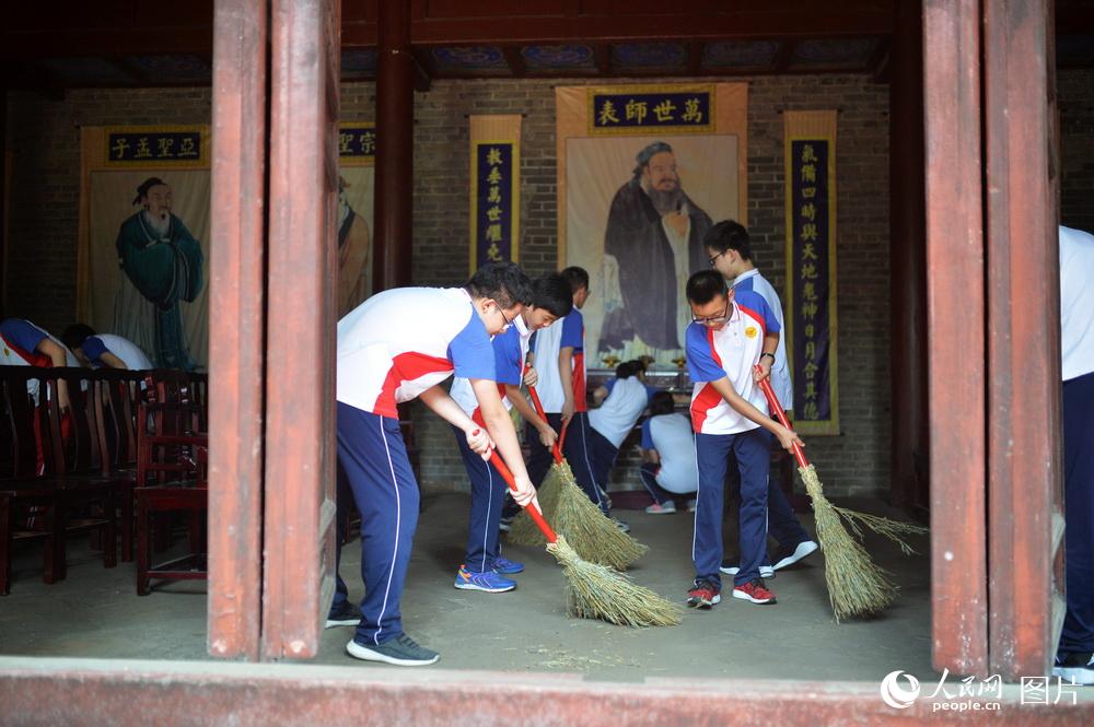 圖為濟南市第二十七中學學生在洙泗書院大成殿內義務勞動。