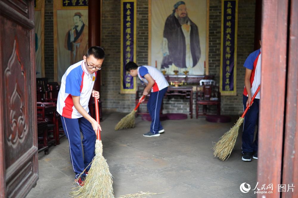 圖為濟南市第二十七中學學生在洙泗書院大成殿內義務勞動。