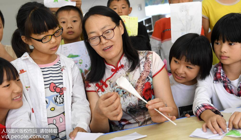 9月8日，戈紹琳（中）帶著孩子們制作教師節賀卡和手工制品。