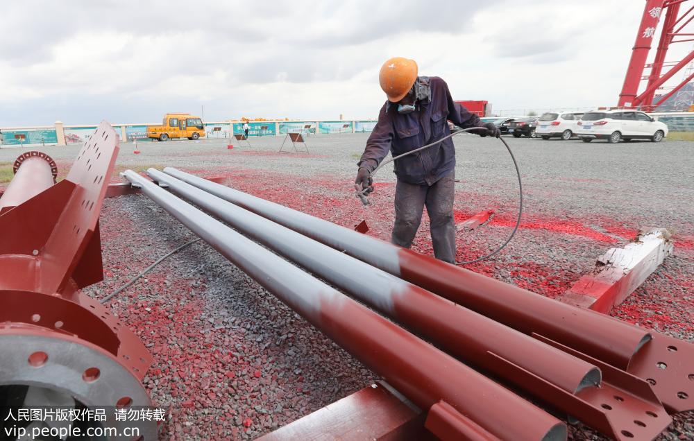 9月10日，一名工作人員在地面上對鋼管塔進行新型石墨烯重防腐涂料的噴刷工作。