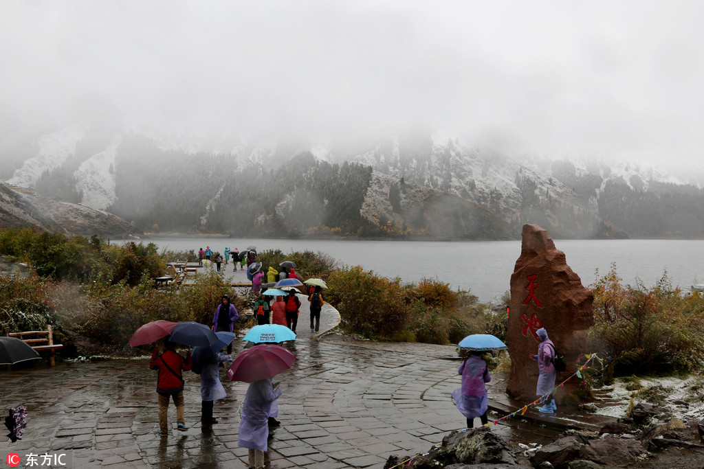 新疆天山天池降下首場雪 市民游客撐傘圍觀【2】