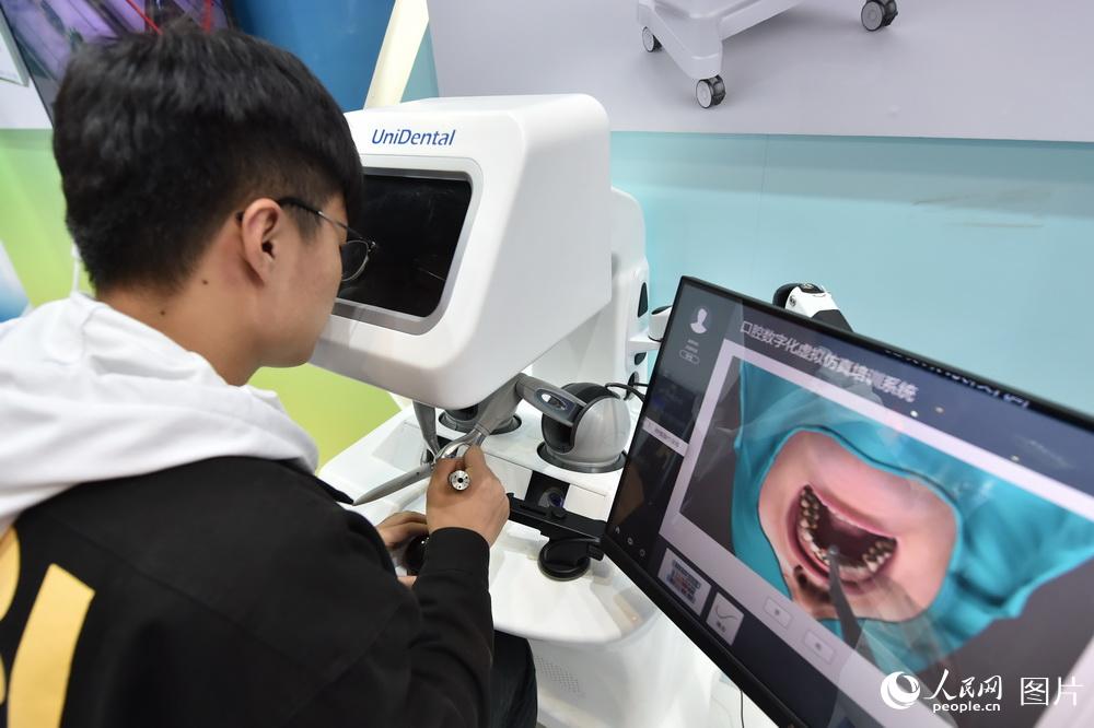 10月10日，在2018年全國雙創周北京會場，觀眾正在操作虛擬現實醫學手術模擬器體驗牙科手術。（人民網記者 翁奇羽）