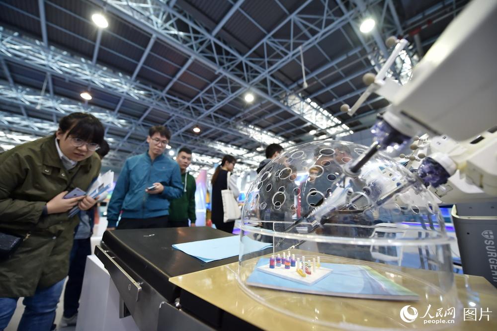 10月10日，在2018年全國雙創周北京會場，觀眾正在認真觀察腔鏡機器人的操作。（人民網記者 翁奇羽）