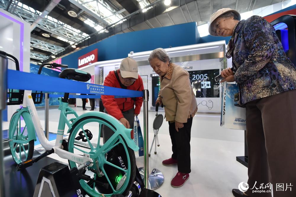 10月10日，在2018年全國雙創周北京會場，幾位老人正在對共享單車的聯動系統進行研究。（人民網記者 翁奇羽）