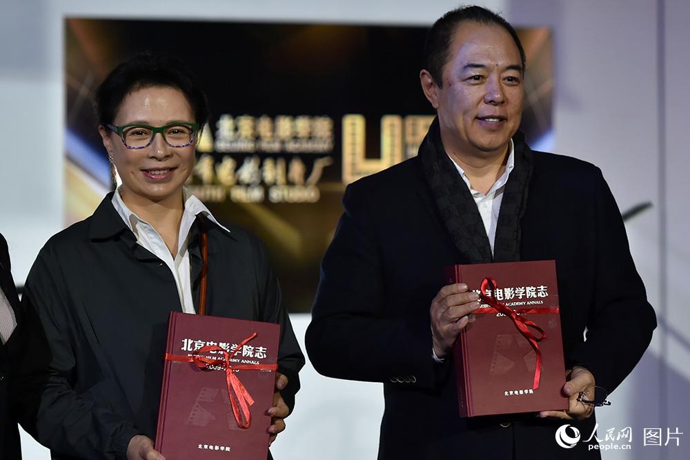 演員張鐵林、劉佳代表78級校友接受校方贈送的北京電影學院校志。（人民網記者 翁奇羽 攝）