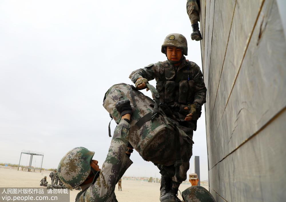 11月2日，训练中官兵紧密配合运送背囊。