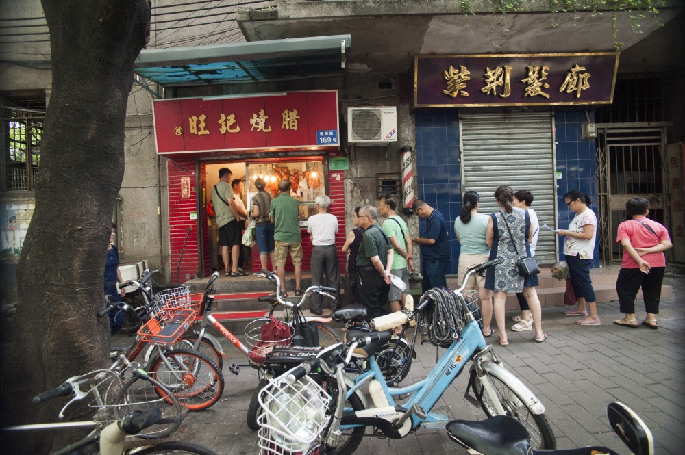 2018年7月31日，廣州荔灣區逢源路，喜歡傳統風味的人們在老字號臘味店排隊購買。司徒志文（中國）攝