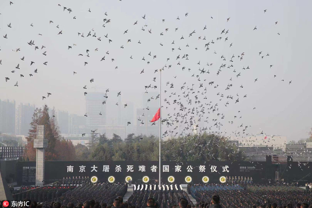 12月13日，公祭仪式现场降半旗放飞和平鸽。