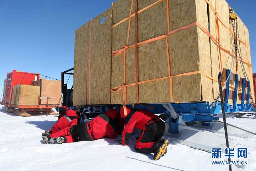 12月21日，科考隊員在檢查和替換被震掉的雪橇螺帽。　　新華社記者劉詩平 攝