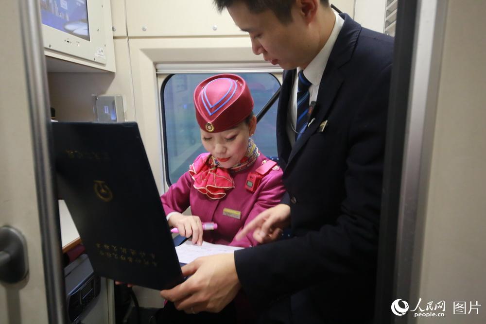 列車長劉玉婷和實習車長一起核實工作台賬。