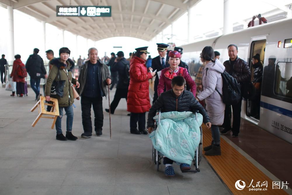 刘玉婷正在帮助一名腿脚不方便的乘客。