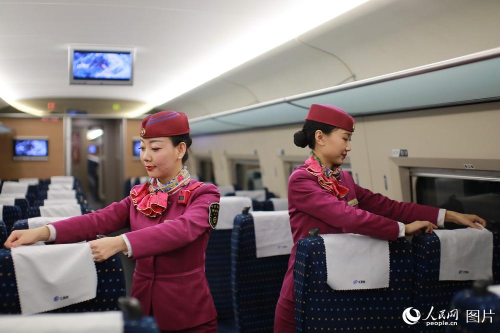 在列車達到車站后，利用間隙時間劉玉婷和同事一起調整座位及頭巾片等，來迎接忙碌的旅客服務工作。