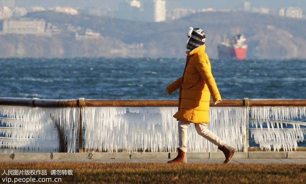 12月27日，市民冒着严寒在大连东港海岸边徒步健身。