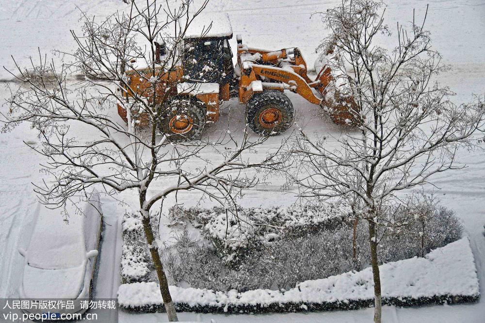 12月27日，環衛工人駕駛清雪機械在山東省煙台市福山區街頭清理積雪。