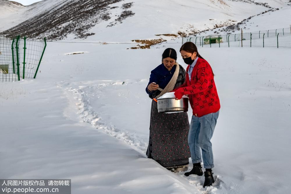2018年12月2日，青海省海西州都蘭縣海拔4200米的溝裡，肉保妻子德措吉和女兒仁青拉毛抬雪化水。