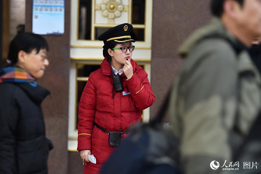 1月21日，北京站，工作人員引導旅客有序進站。（人民網記者 翁奇羽 攝）