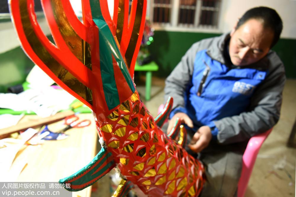 1月23日晚，湖南省城步苗族自治縣丹口鎮下團村吊龍隊的成員在扎制即將完工的龍尾。