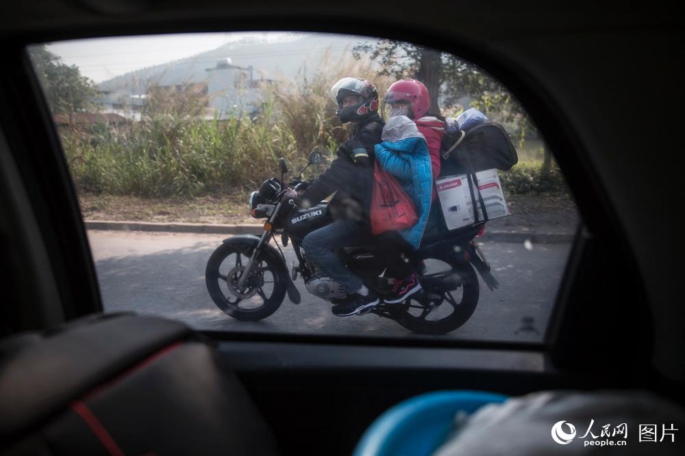 2019年1月24日，廣東佛山。一位務工者騎著摩托車帶著自己妻子在返鄉途中。