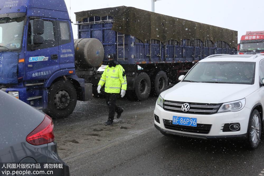 1月28日，民警在連霍高速新疆哈密星星峽段指揮交通。