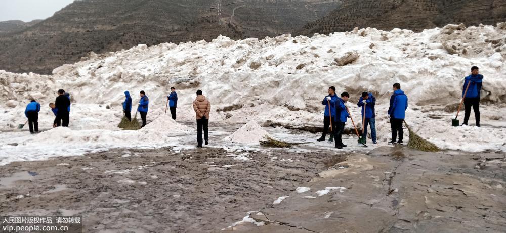 1月30日，山西省吉縣黃河壺口瀑布景區工作人員用挖掘機鏟除冰雪。