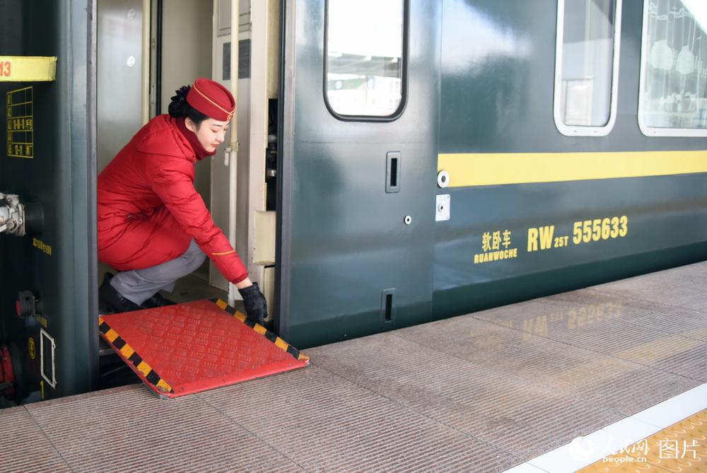1月31日，內蒙古呼和浩特，列車長員王瑤准備立崗接車，並放下腳踏板。