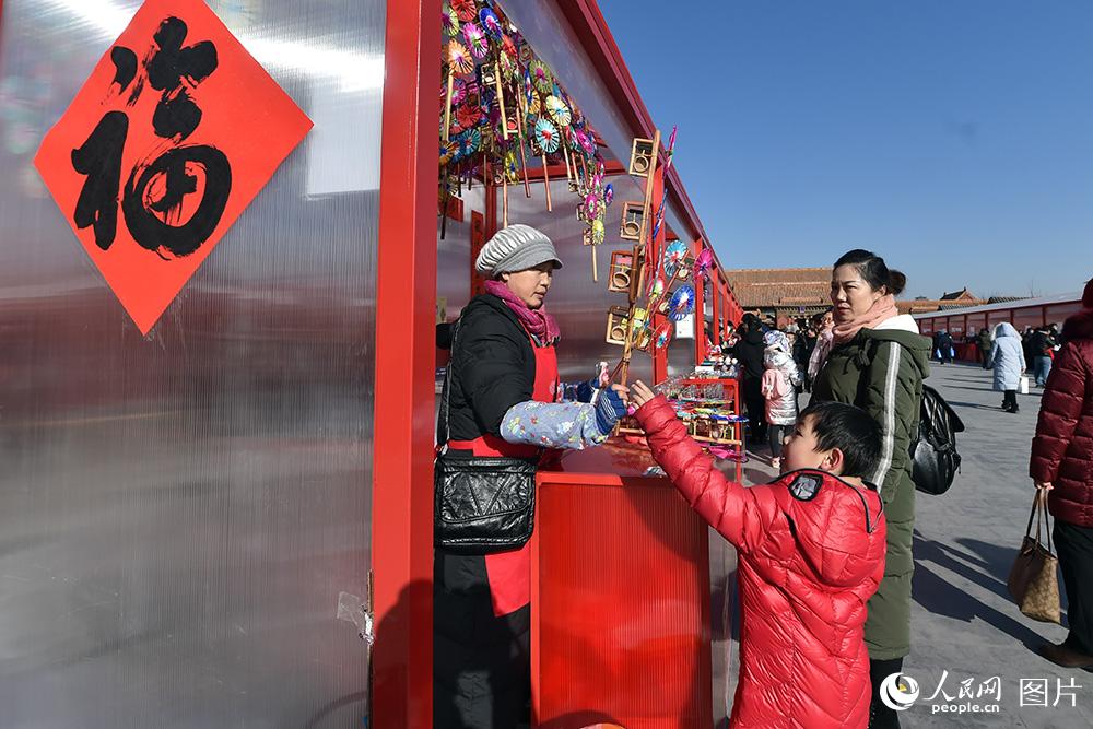 2月1日，在“中华老字号故宫过大年展”上，小朋友正在挑选老字号玩具。（人民网记者 翁奇羽 摄）