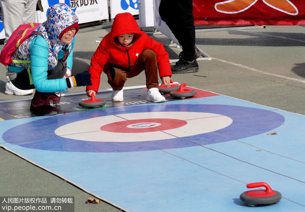 2月7日，在北京國際雕塑公園，游人體驗陸地冰壺運動。（李文明/人民圖片）