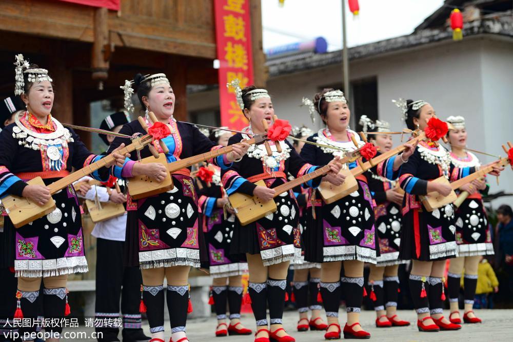 2月10日，在廣西龍勝各族自治縣平等鎮廣南村鼓樓前，侗族同胞在彈唱琵琶歌。