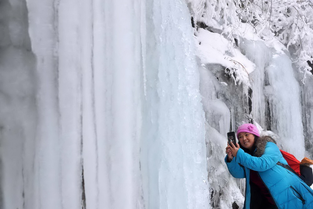 游客在重慶黔江國家森林公園八面山景區拍攝冰瀑。楊敏 攝