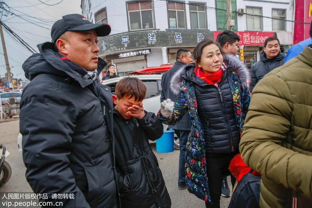 2月9日，看著上車打工的人，趙海霞含淚與家人分別。
