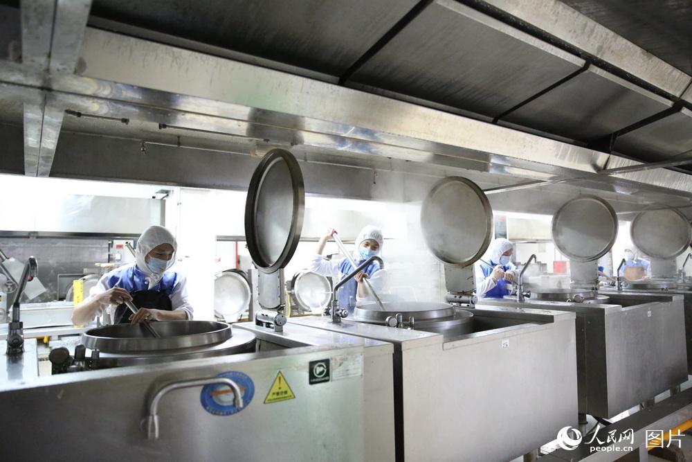 熱調理區工作人員正在對菜品進行熟制。蘇志剛 攝影