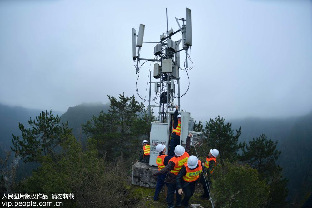2019年2月22日，在湖北省宣恩县两溪河村的一处至高点上，工人在对一处通讯铁塔进行最后的施工和调试。