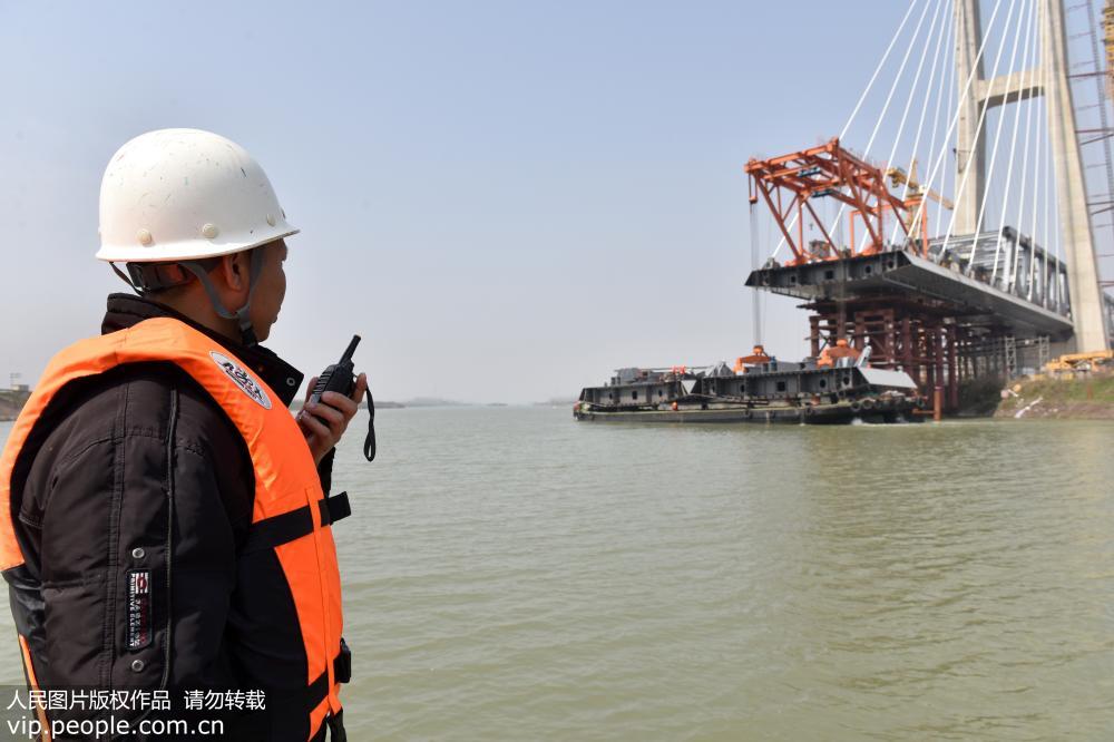 3月11日，在安徽省含山縣，商合杭鐵路跨裕溪河特大橋進行鋼箱梁架設，技術人員正在指揮作業。