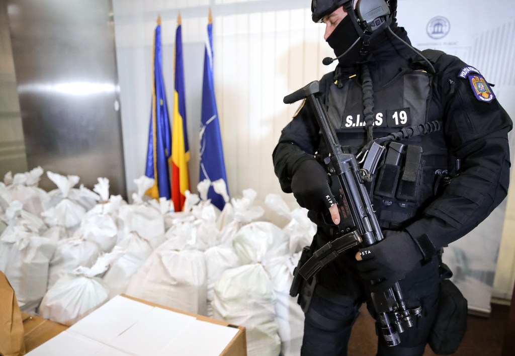 3月26日,在罗马尼亚布加勒斯特,一名警察站在查获的可卡因旁.