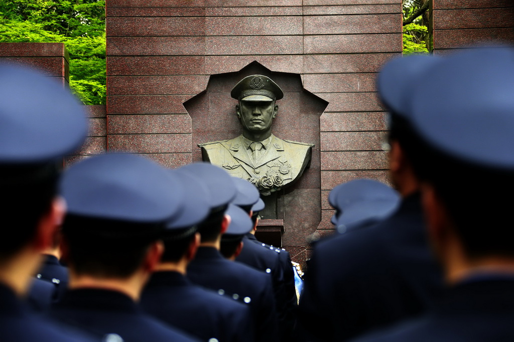 4月2日，江蘇出入境邊防檢查總站民警在公安英烈紀念牆前默哀。新華社發（章善玉 攝）