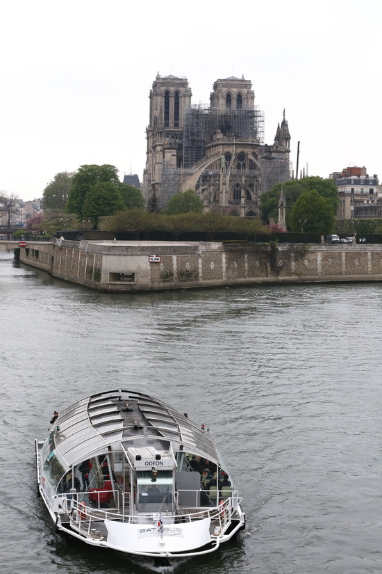 4月16日，在法国巴黎，一艘游船经过火灾后的巴黎圣母院。 新华社记者高静摄