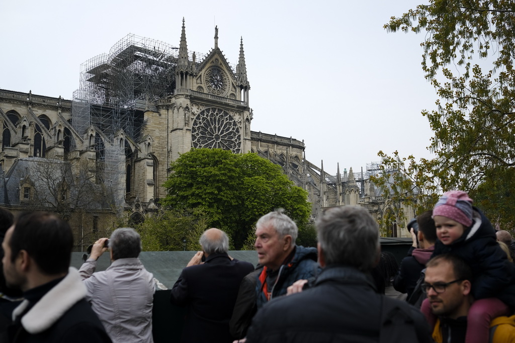 4月16日，在法国巴黎，人们观看火灾后的巴黎圣母院。新华社发（亚历山大·卡曼摄）