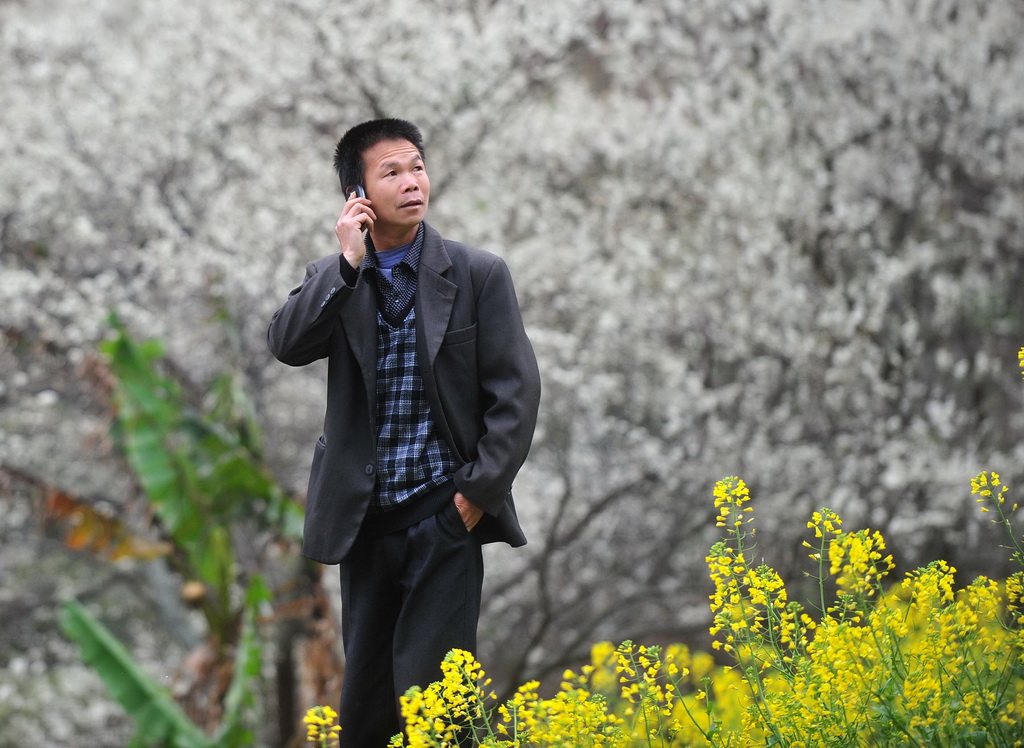 2014年2月21日，龍革雄在打電話聯系業務。 新華社記者 黃孝邦 攝