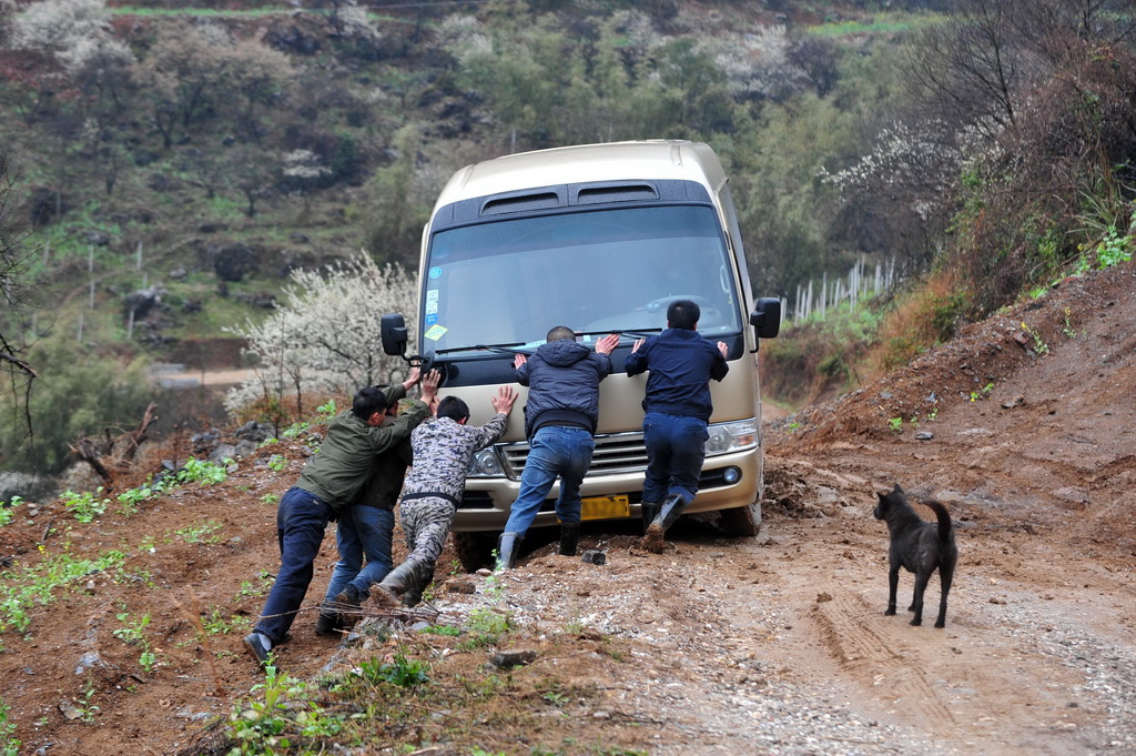 2014年2月22日，村民們推著車輛經過濕滑路段進入銅板屯。新華社記者 黃孝邦 攝