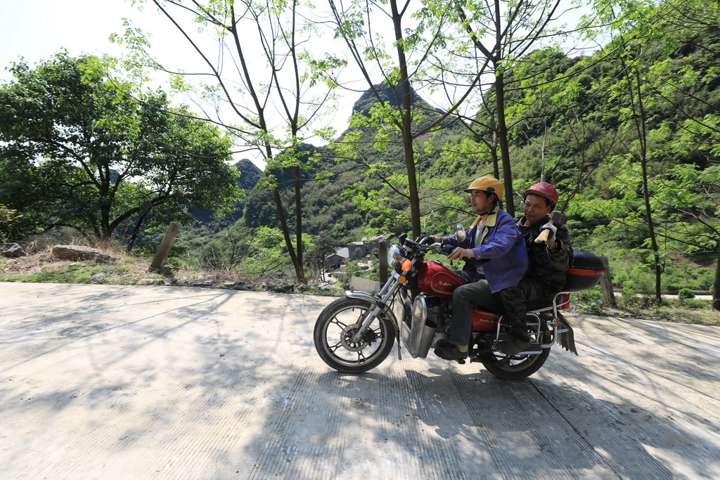 2019年4月16日，“融安縣銅板高山果品農民專業合作社”的村民騎車去勞作。新華社記者 黃孝邦 攝