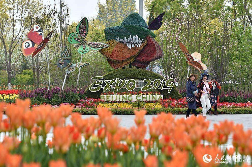 4月29日，游客在世園會主題花壇前拍照留念。