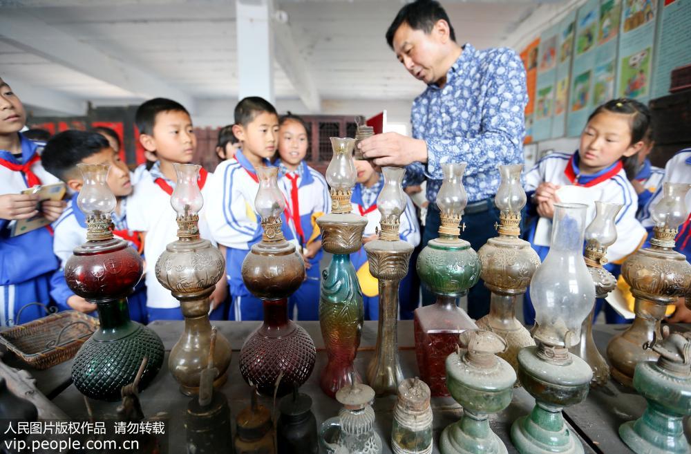 5月5日，孫先勇為山東青島市即墨區龍泉中心小學的學生講解傳統煤油燈的常識。