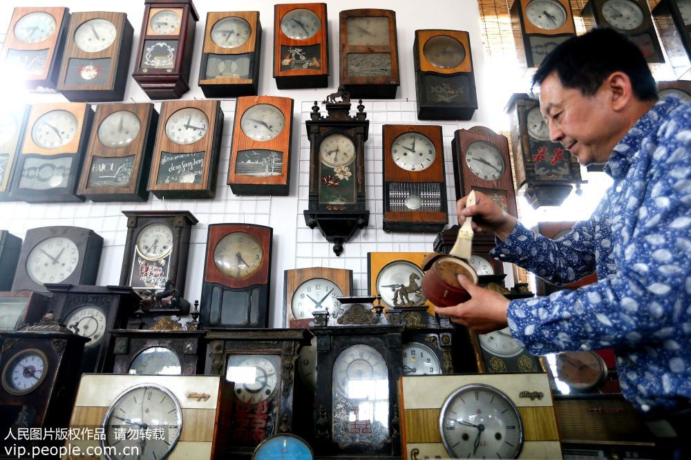 5月5日，孫先勇在擦拭收藏來的各式傳統挂鐘。