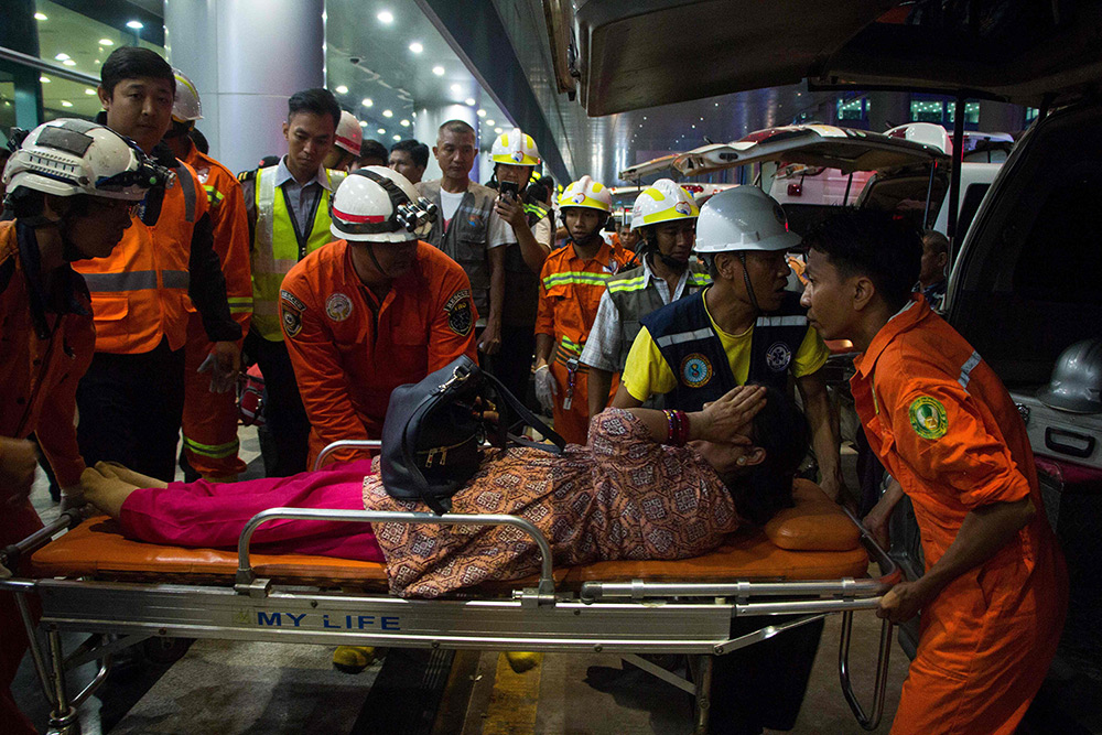 5月8日，在緬甸仰光國際機場，工作人員在救護事故中的傷者。新華社/法新