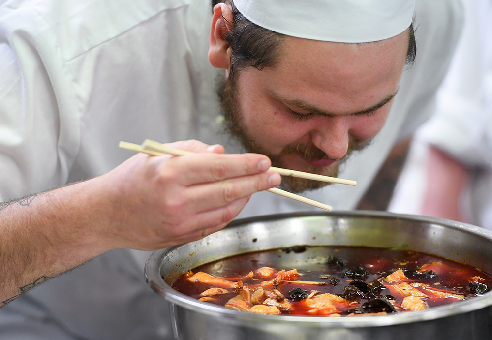 5月13日，在新西蘭首都惠靈頓理工學院，一名西廚班學員仔細聞火鍋湯底的香味。