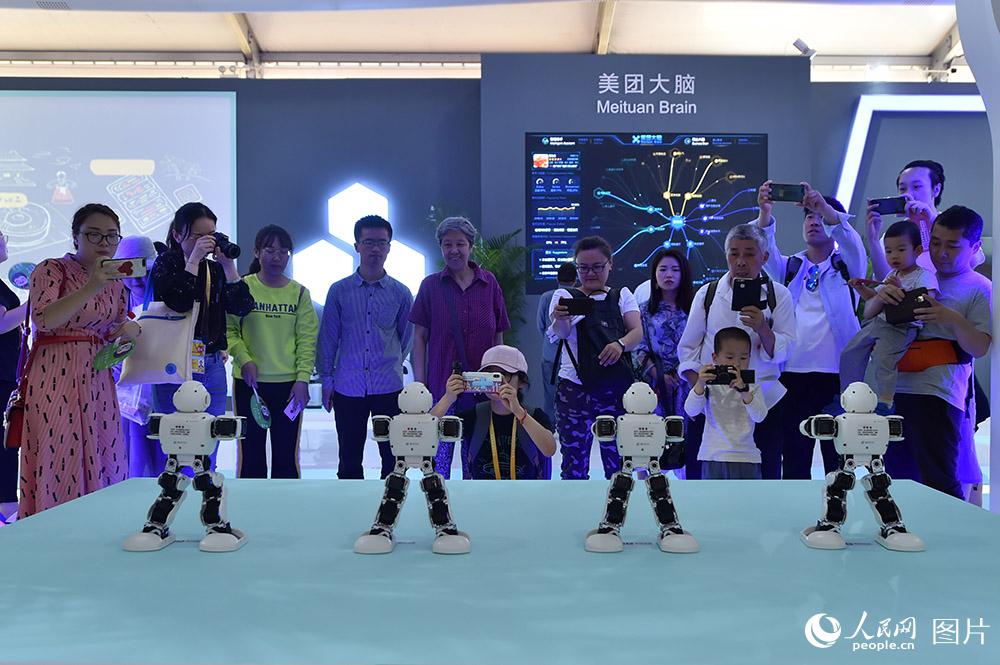 在美食節美團展台，智能機器人舞蹈吸引大人孩子駐足圍觀。
