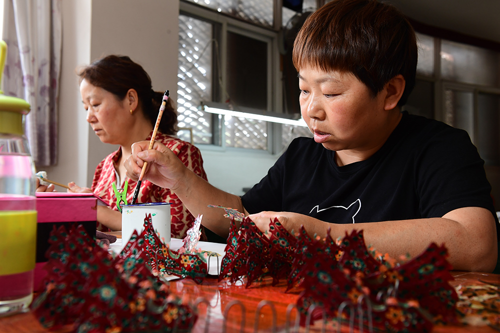 5月23日，華州影子坊皮影制作工人為皮影上色。