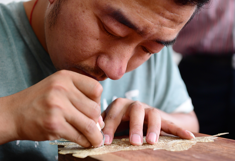 5月23日，華州影子坊皮影制作工人在雕刻皮影。