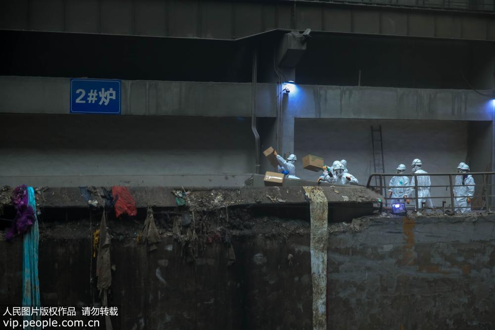5月31日，在青島市某焚燒工廠，青島市公安局禁毒支隊民警和工作人員將毒品扔進焚燒爐。